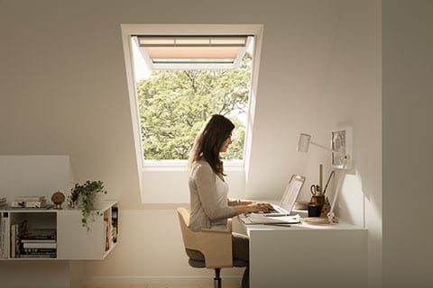 https://b2062430.smushcdn.com/2062430/wp-content/uploads/2020/03/top-hung-roof-window-with-woman-working.jpg?lossy=0&strip=1&webp=1