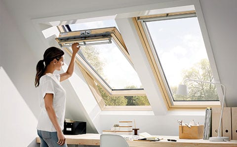 woman opening VELUX roof window